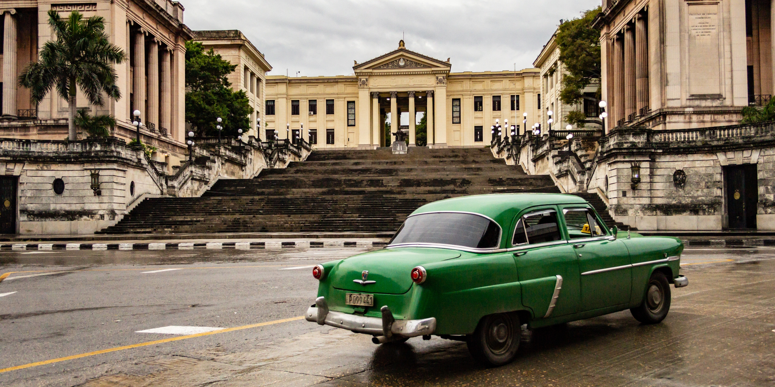 'La Esquina' by Brett Robert Looking towards the steps of the Universidad de la Habana during a break in the rain as a car passes by.